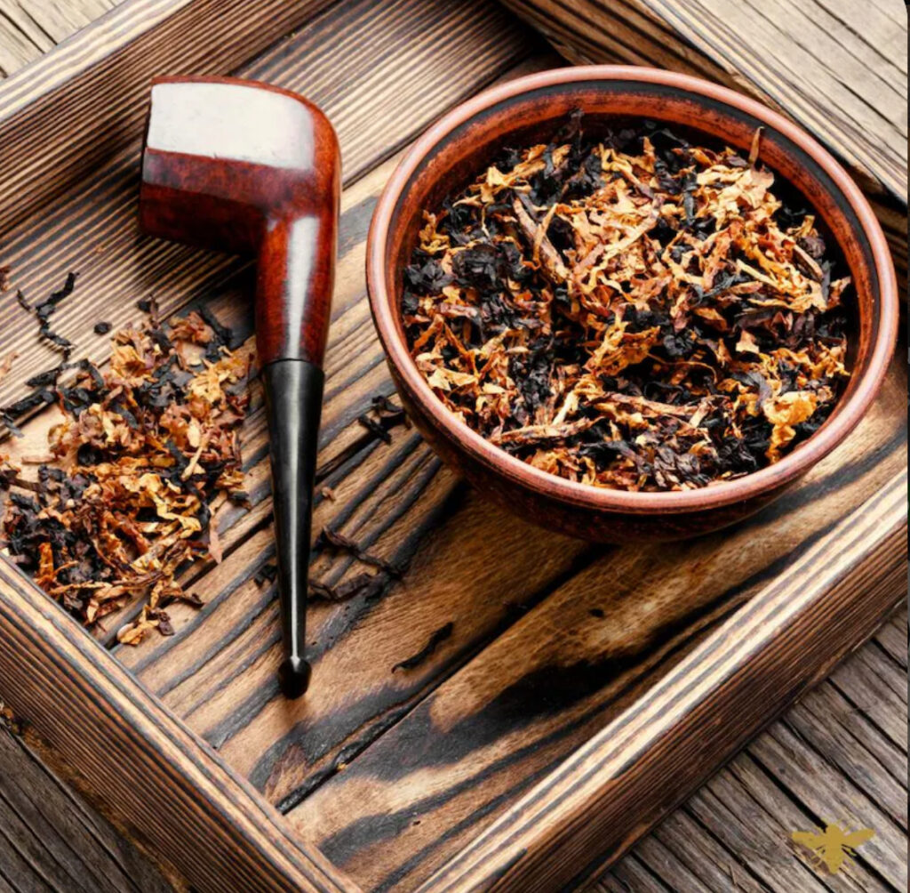 Pipe and tobacco on wooden tray.